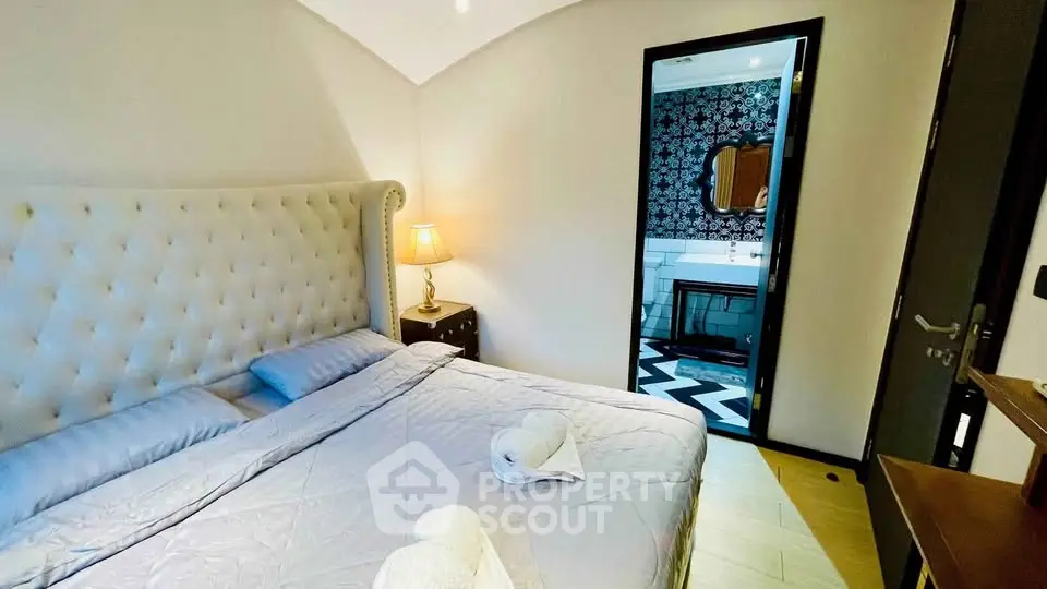 Luxurious bedroom with ensuite bathroom featuring elegant decor and plush bedding.
