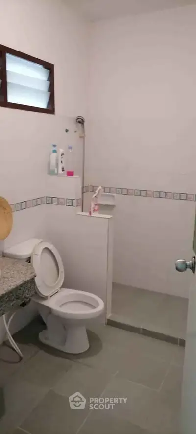 Cozy bathroom with modern fixtures and tiled shower area in a residential property.