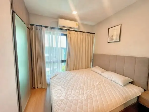 Cozy bedroom with modern decor and large window for natural light