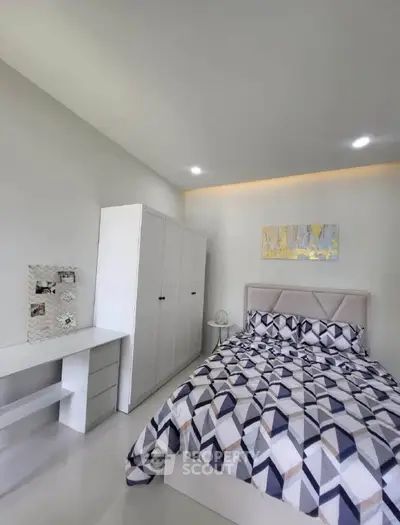 Modern bedroom with geometric bedding and sleek white furniture