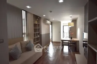Modern living room with dining area, featuring wooden flooring and stylish decor.