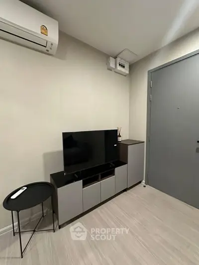 Modern living room with sleek TV unit and air conditioning, perfect for cozy urban living.