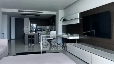 Modern open-plan living room with sleek kitchen and large TV