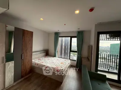Modern bedroom with city view and balcony access in high-rise apartment