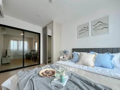 Modern bedroom with stylish decor and sliding glass doors leading to a cozy living area.
