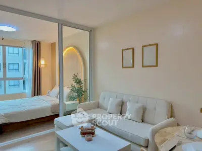 Modern living room with cozy white sofa and adjacent bedroom view