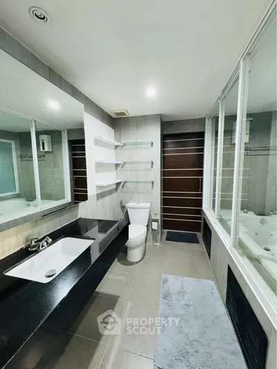 Modern bathroom with sleek design, featuring a bathtub and spacious layout.
