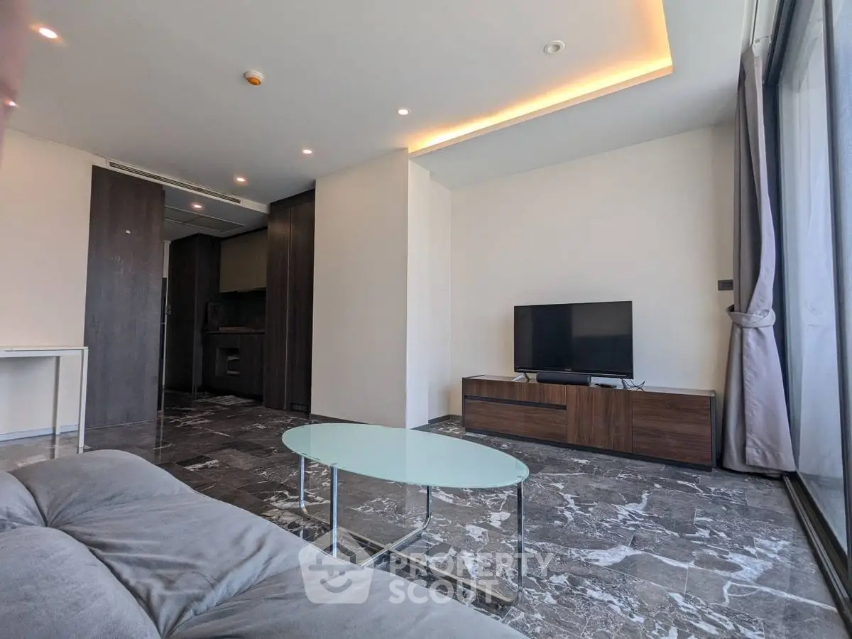 Modern living room with sleek design, marble flooring, and large windows for natural light.