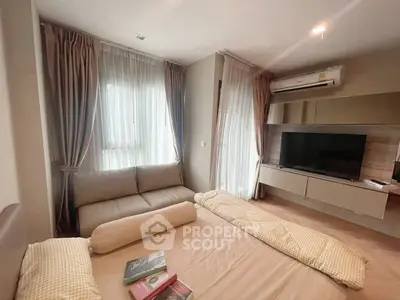 Cozy bedroom with modern decor, featuring a comfortable bed, sofa, and wall-mounted TV.