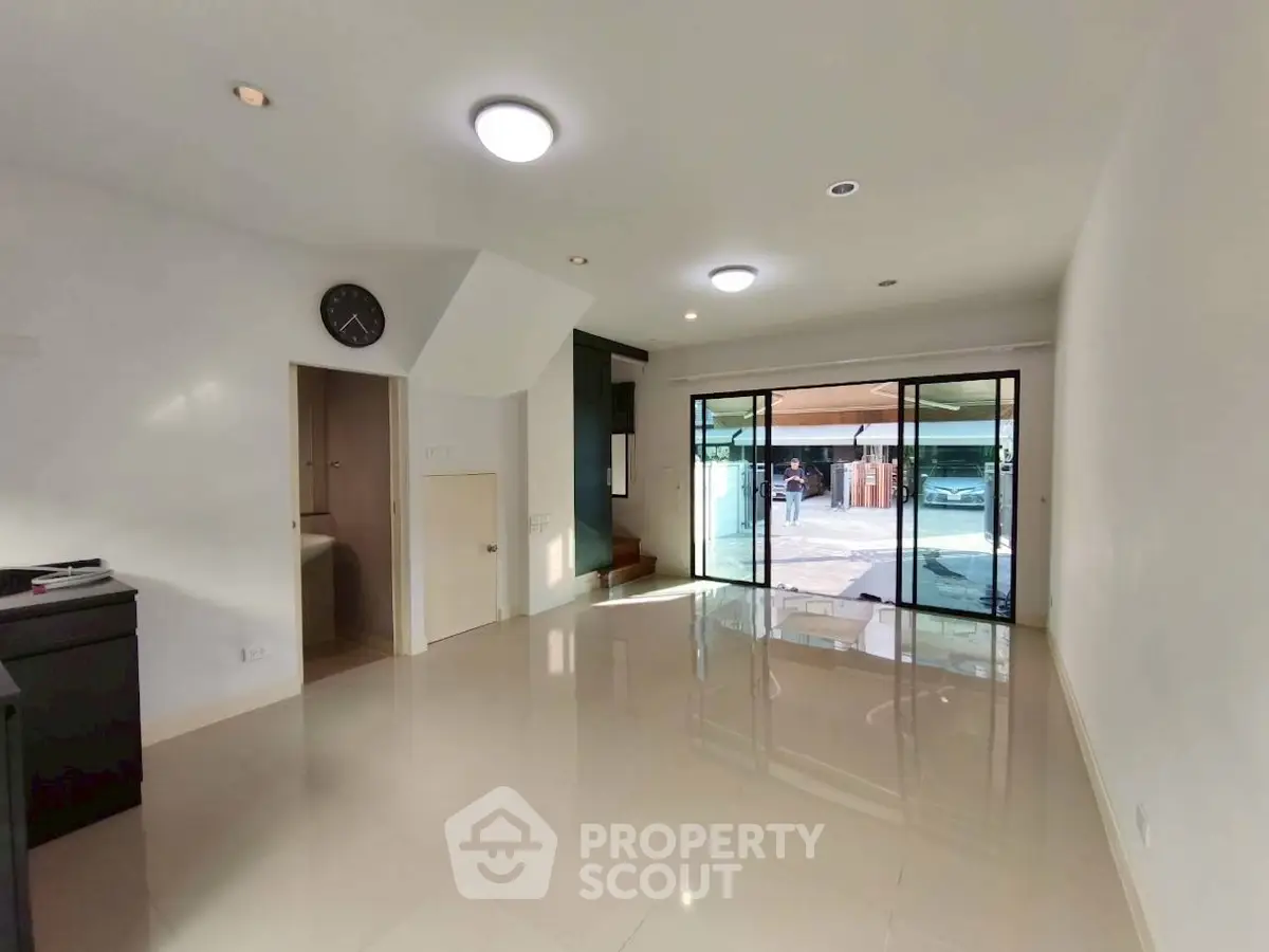 Spacious modern living room with large windows and glossy tiled floors