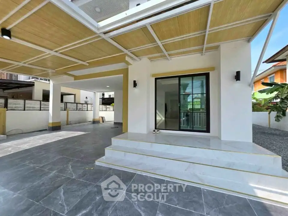 Modern house exterior with spacious tiled patio and stylish entrance