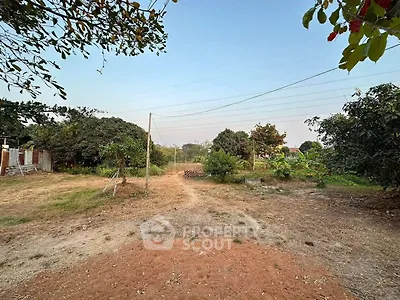 Expansive plot of land with lush greenery and clear sky, perfect for development.