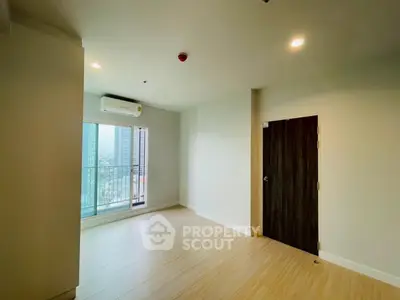 Spacious unfurnished room with large window and city view, ideal for customization.