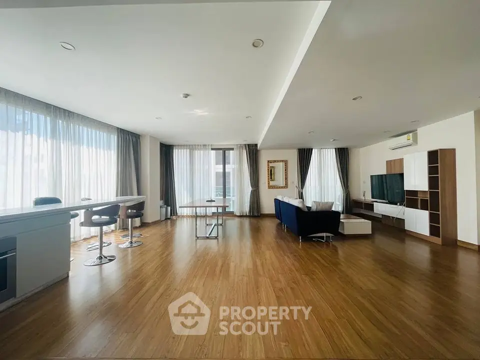 Spacious modern living room with large windows and elegant furnishings