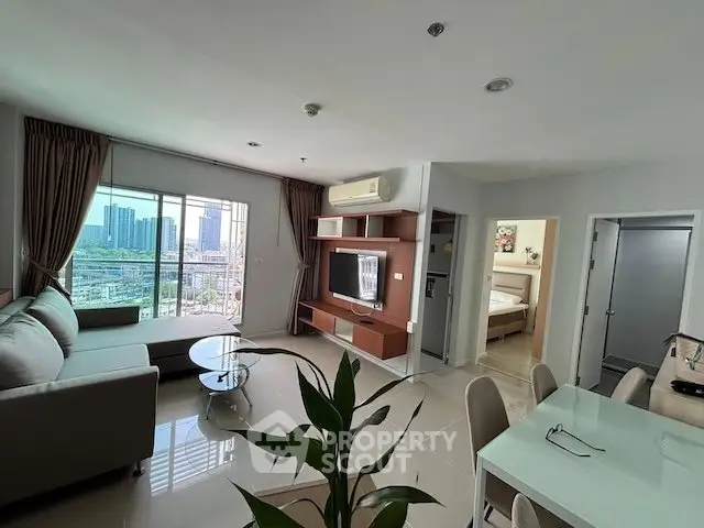 Spacious modern living room with city view, featuring sleek furniture and open layout.