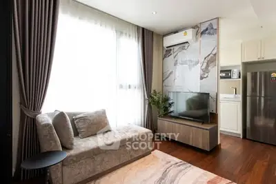 Modern living room with stylish decor and natural light, featuring a cozy sofa and sleek entertainment unit.