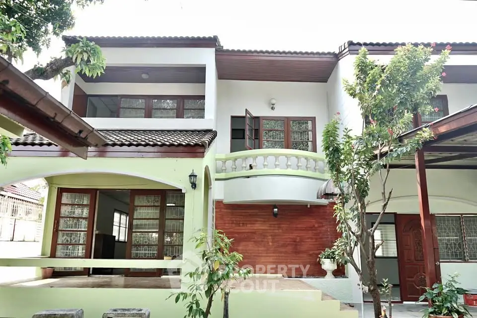 Charming two-story house with lush garden and spacious balcony, perfect for family living.