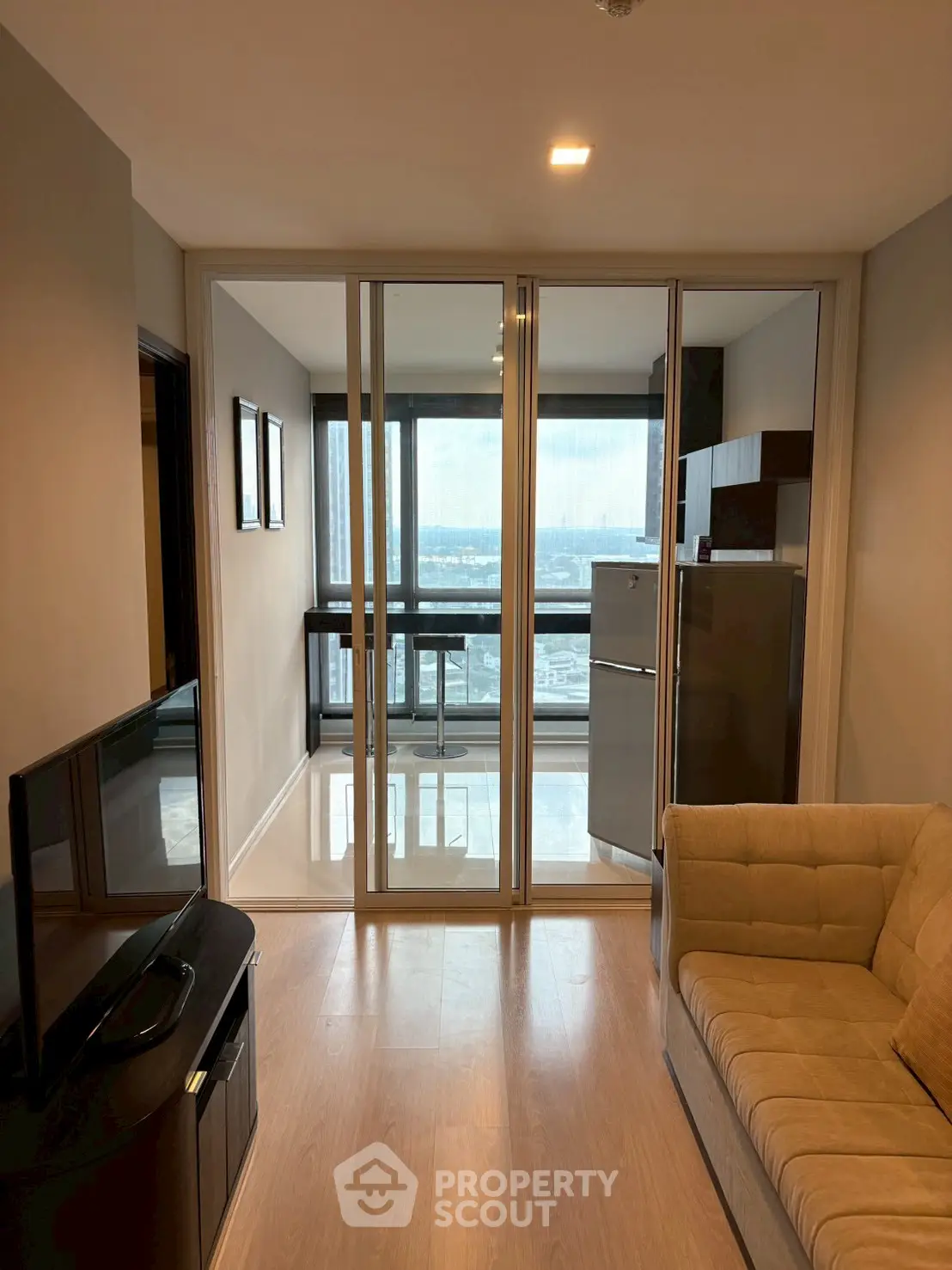 Modern living room with glass doors leading to a balcony with a stunning view.