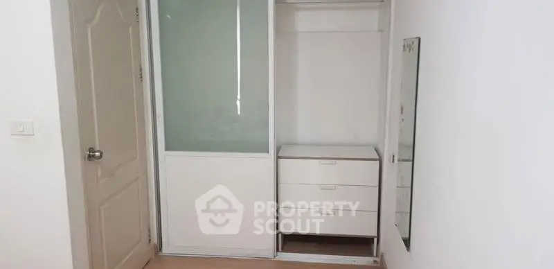 Minimalist bedroom with sliding closet and mirror, perfect for modern living.