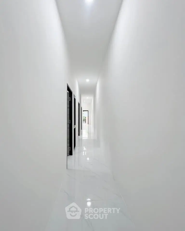 Sleek modern corridor with glossy white floors and minimalist design.