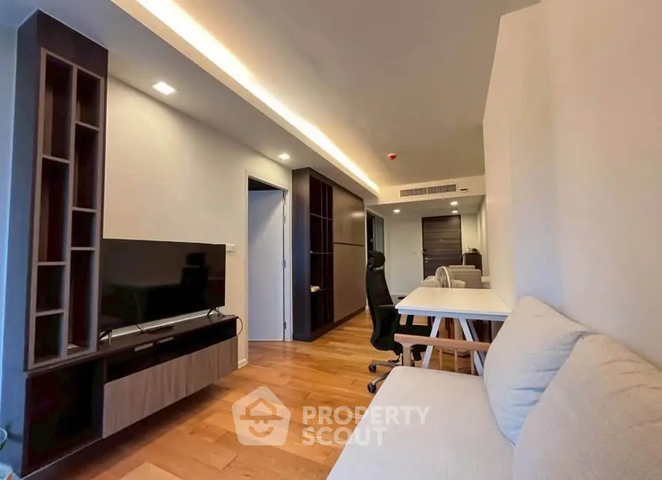Modern living room with wooden flooring, stylish furniture, and ambient lighting.