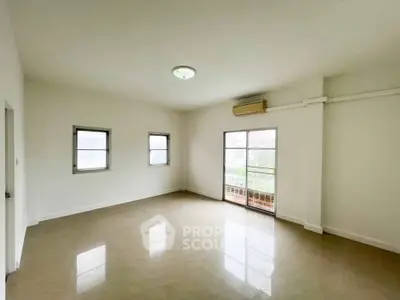 Spacious unfurnished room with large windows and balcony access, ideal for customization.