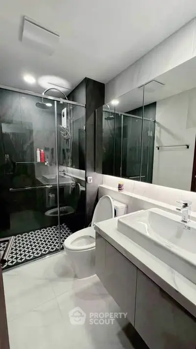 Modern bathroom with sleek design, glass shower enclosure, and elegant fixtures.
