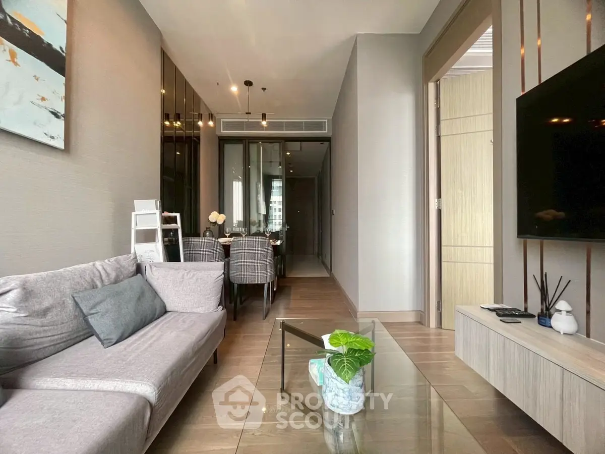 Modern living room with stylish decor and dining area in open layout apartment.