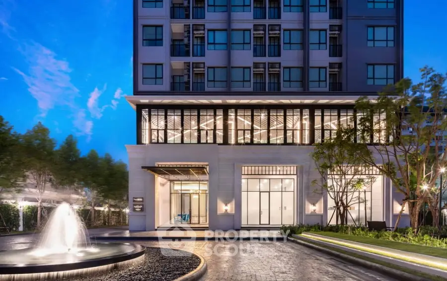Stunning modern building exterior with elegant entrance and illuminated windows at dusk.