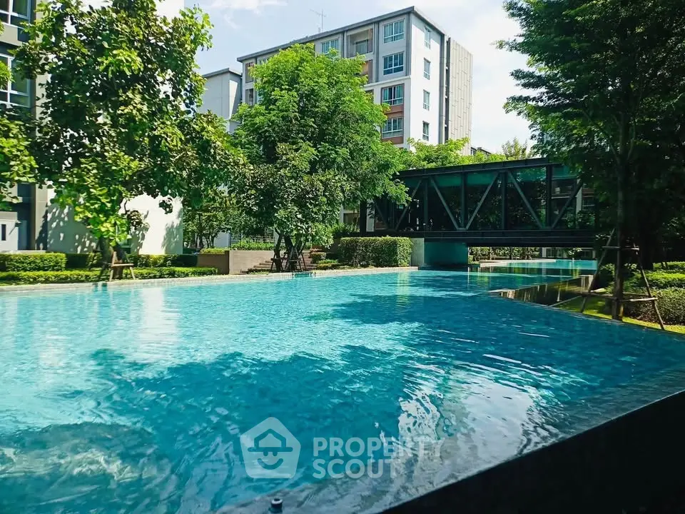 Luxurious apartment complex with a stunning pool and lush greenery