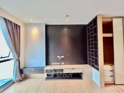 Modern living room with built-in shelves and large window, perfect for stylish urban living.