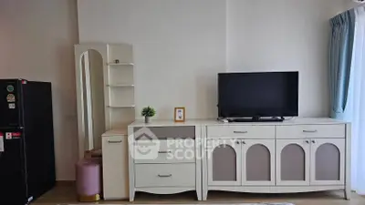 Modern living room with stylish white furniture and TV setup, perfect for cozy relaxation.
