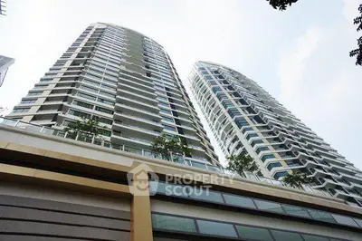 Stunning modern high-rise residential building with sleek architecture and lush greenery.