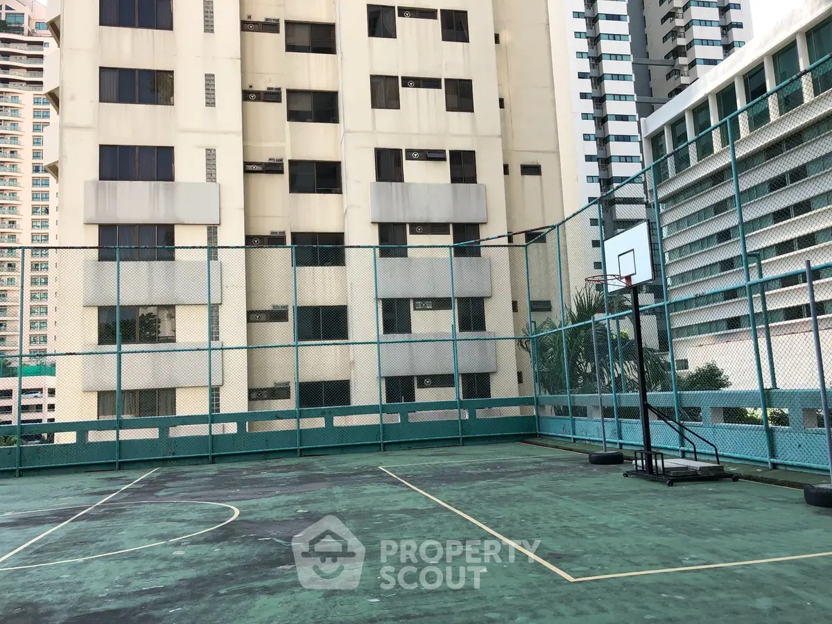 Urban rooftop basketball court with city building backdrop, ideal for sports enthusiasts seeking unique amenities.