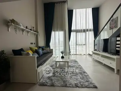 Spacious modern living room with high ceilings and large windows offering city views.