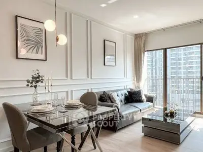 Modern living room with elegant decor and large windows offering city views.