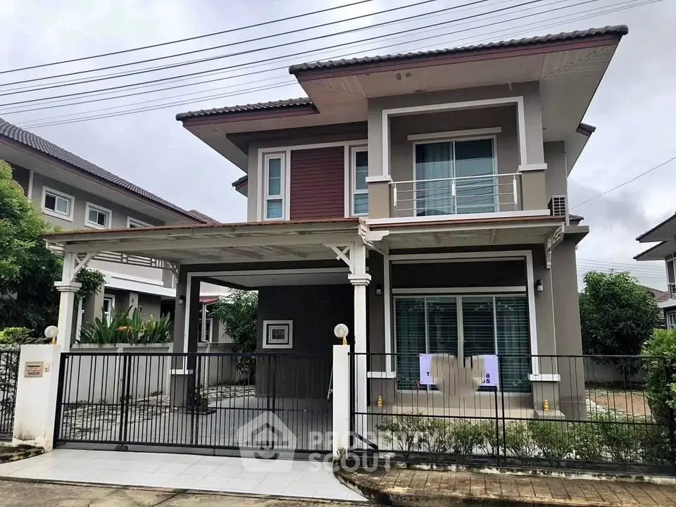 Modern two-story house with spacious driveway and balcony in suburban neighborhood.