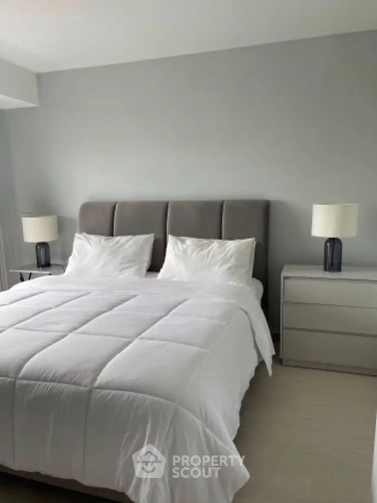 Modern bedroom with stylish gray headboard and sleek white bedding