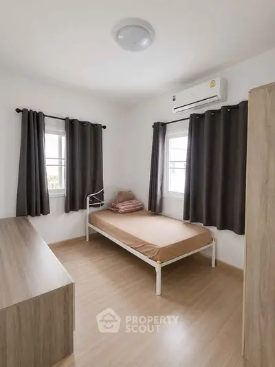 Cozy minimalist bedroom with natural light and modern furnishings.