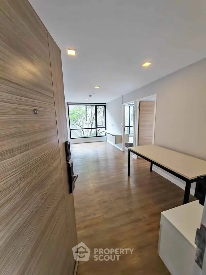 Spacious modern living room with large windows and wooden flooring, perfect for natural light lovers.