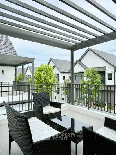 Spacious balcony with modern outdoor furniture and scenic neighborhood view.