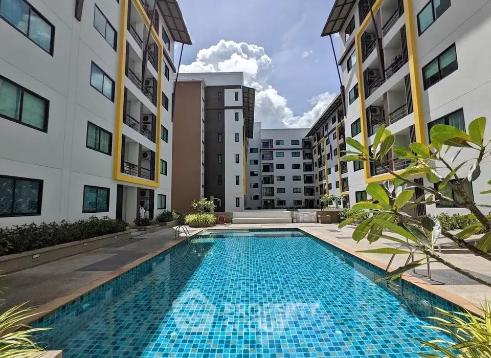 Modern apartment complex with a stunning outdoor pool and lush greenery.