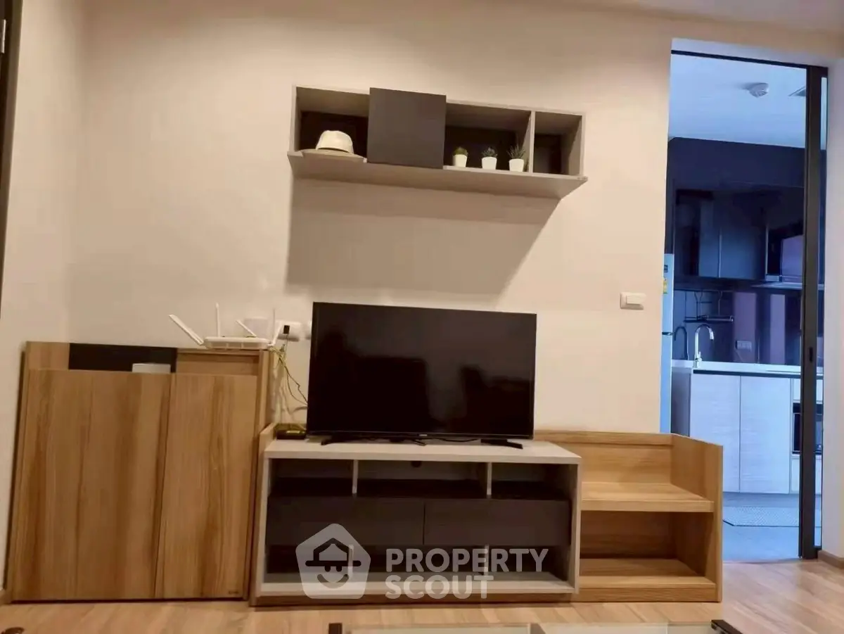 Modern living room with sleek TV stand and open kitchen view, perfect for contemporary urban living.