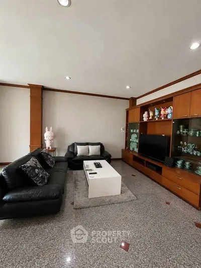Spacious living room with elegant leather sofas and modern entertainment center.