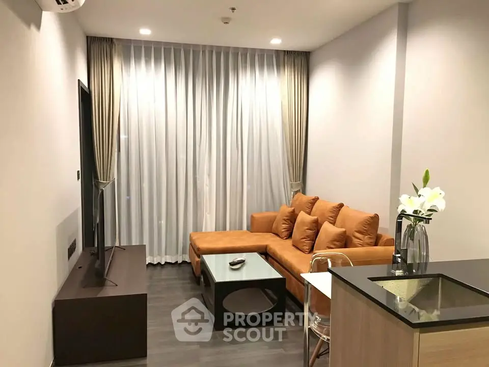 Modern living room with sleek furniture and floor-to-ceiling curtains in a stylish apartment.