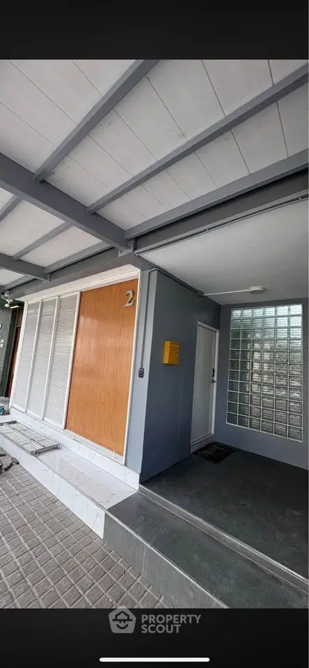 Modern building entrance with sleek design and glass block wall, showcasing contemporary architecture.
