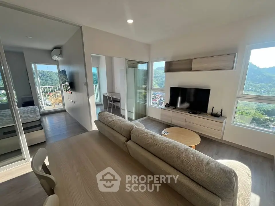 Modern living room with scenic view, open layout, and stylish furniture in a bright apartment.