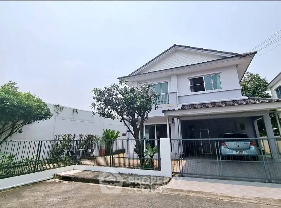 Charming two-story house with carport and lush garden in a serene neighborhood.