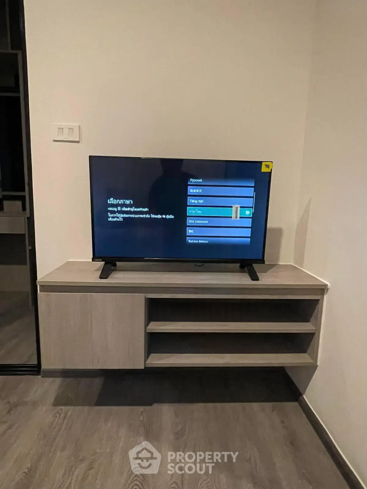 Modern living room with sleek TV setup and stylish wooden console.