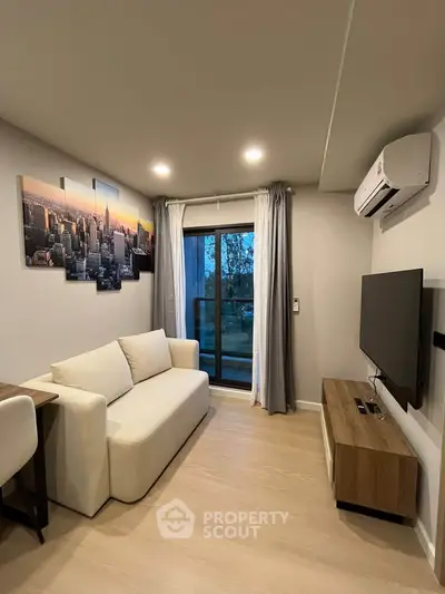 Modern living room with sleek furniture and cityscape artwork, featuring a cozy sofa and wall-mounted TV.